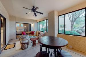 ein Wohnzimmer mit einem Deckenventilator und einem Tisch in der Unterkunft Villas at Hacienda del Sol #11101 in Tucson