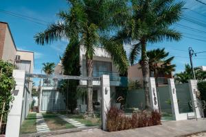 a house with palm trees in front of it at Casa de Temporada Homer House in Porto Seguro