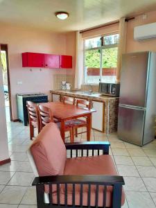 a kitchen with a table and a refrigerator at Vaiana Home 2 - bord de lagon in Taputapuapea