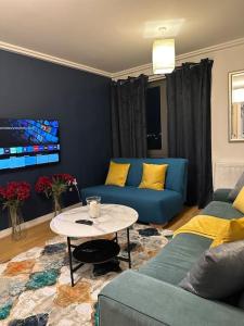 Entire flat in Ealing في لندن: غرفة معيشة مع أريكة زرقاء وطاولة