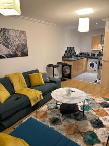 ein Wohnzimmer mit einem Sofa und einem Tisch in der Unterkunft Entire flat in Ealing in London