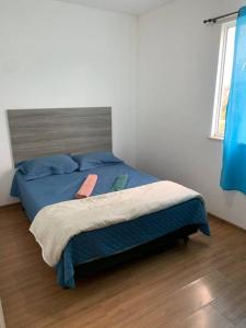 - une chambre avec un lit et une couette bleue dans l'établissement Condomínio Park Jardim Norte, à Juiz de Fora