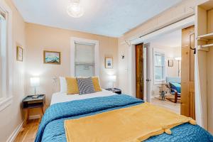 ein Schlafzimmer mit einem großen Bett mit blauer und gelber Bettwäsche in der Unterkunft Northwoods Oasis in Presque Isle