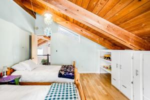 1 Schlafzimmer mit 2 Betten und Holzdecke in der Unterkunft Cozy Retreat in Girdwood