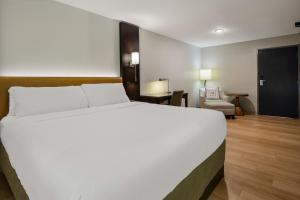 a large white bed in a hotel room at The Marco Hotel Lake Charles in Lake Charles