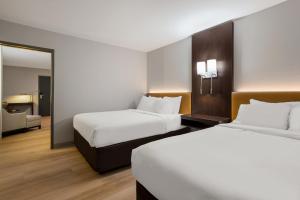 Un pat sau paturi într-o cameră la The Marco Hotel Lake Charles