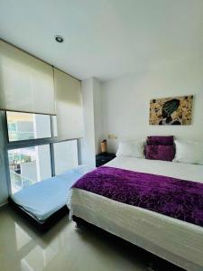 a bedroom with a large bed with purple sheets at morros epic luxury in Cartagena de Indias