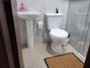 a bathroom with a toilet and a sink at Casa das Embaúbas 1 in São José
