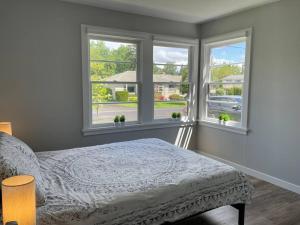 ein Schlafzimmer mit einem Bett und zwei Fenstern in der Unterkunft Modern 3 Bedroom Home in Beaverton in Beaverton