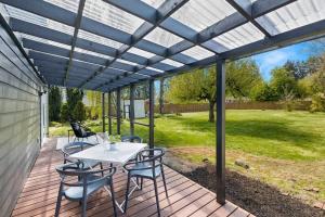 eine Terrasse mit einem Tisch und Stühlen auf einer Terrasse in der Unterkunft Modern 3 Bedroom Home in Beaverton in Beaverton