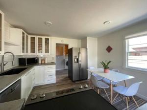 eine Küche mit einem Tisch und einem Kühlschrank aus Edelstahl in der Unterkunft Modern 3 Bedroom Home in Beaverton in Beaverton