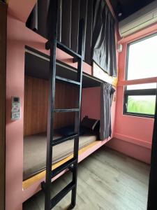 a room with bunk beds in a train with a window at Good hostel 好棧 Green Island in Green Island