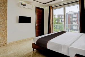 a bedroom with a bed and a large window at Collection O Vikrant Residency in Gurgaon
