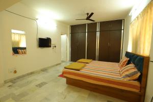 a bedroom with a bed with a ceiling fan at ROHAN HOUSE in Nashik