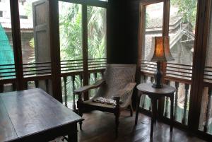 a room with a table and a chair and a lamp at Villa Guest House in Bangkok