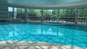 a large swimming pool in a building with windows at 潍坊富华大酒店b座 in Weifang