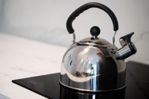 a silver and black tea kettle on a stove at Deluxe 2BDRs Home in Spa District Center in Karlovy Vary