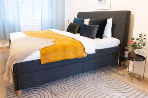 a bedroom with a large bed with a yellow blanket at Deluxe 2BDRs Home in Spa District Center in Karlovy Vary