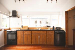 cocina con armarios de madera, fregadero y ventana en Hilltop on Milton en Napier