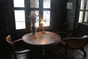 a table with a lamp and a vase on it at Villa Guest House in Bangkok +35 photos