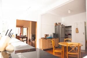 a kitchen with a table and chairs and a refrigerator at Hilltop on Milton in Napier +13 photos