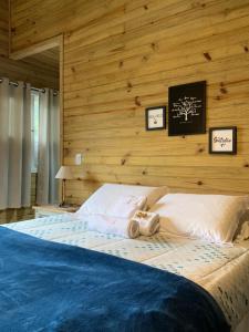 um quarto com uma cama grande e uma parede de madeira em Estalagem Villa Serrana em Urubici