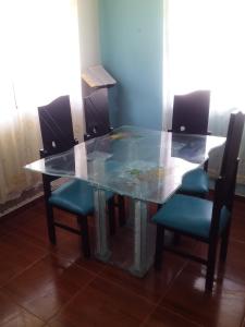una mesa de comedor de cristal con 4 sillas alrededor en Manantial amazónico, en Mocoa