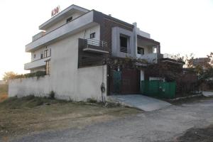 a white house with a gate and a fence at AIRWAYS B&B Islamabad Free Airport Pick and Drop in Islamabad