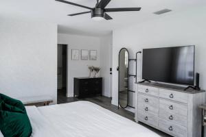 um quarto com uma cama e uma televisão de ecrã plano em Great Location, 10 Mins to Beach, Vero Pool House em Vero Beach