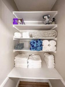 a closet with white shelves with towels at Great Location, 10 Mins to Beach, Vero Pool House in Vero Beach