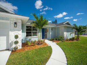 a house with a palm tree in the front yard at Great Location, 10 Mins to Beach, Vero Pool House in Vero Beach