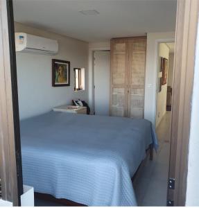 um quarto com uma cama azul num quarto em Engenho da Praia em Porto de Galinhas