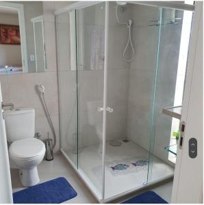 uma casa de banho com uma cabina de duche em vidro e um WC. em Engenho da Praia em Porto de Galinhas
