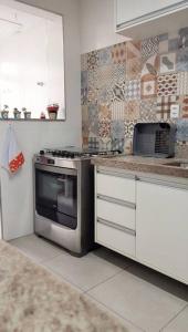 a kitchen with a stove and a counter top at Excelente acomodação e localização. in Santos