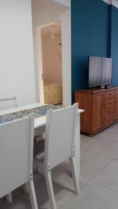 a room with a table and two chairs and a tv at Excelente acomodação e localização. in Santos