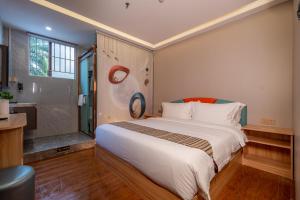 a bedroom with a large bed and a bathroom at Shengda Hotel Zhuhai in Zhuhai