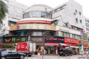 a building with many signs on it on a street at Shengda Hotel Zhuhai in Zhuhai