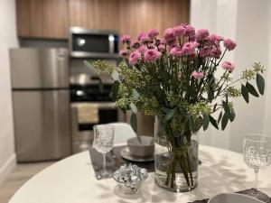 a vase of pink flowers on a table in a kitchen at Cozy 1BR 1BA apt center of LA steps from the Grove in Los Angeles