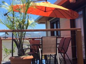 a table and chairs with an umbrella on a balcony at Karenga appartel Tontouta in La Tontouta