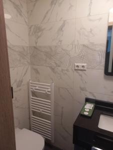 uma casa de banho com um WC branco e um lavatório. em Cafe Hotel centrum em Bruchsal
