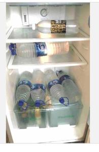 an open refrigerator filled with water bottles at Private suite with living room in Kānpur