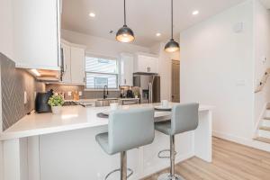 a kitchen with a white counter and two chairs at Luxury Charming 3BR 3Bath Free Wi-FI 8 Guests, Gated Home, Houston Downtown in Houston