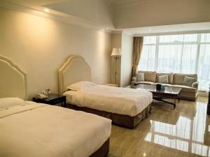 Postel nebo postele na pokoji v ubytování Qingdao Jianxin International Hotel