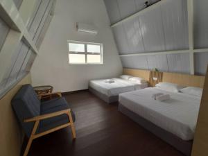 a bedroom with two beds and a chair and a window at Kesang Farm Jasin Melaka by I Housing in Jasin