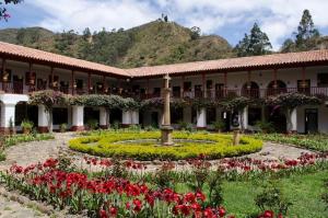 a courtyard of a building with a garden with flowers at Casa Custodia in Ráquira