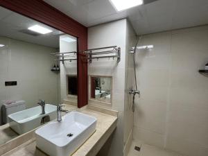 uma casa de banho com um lavatório e um espelho em 张家界喜见客栈 em Zhangjiajie