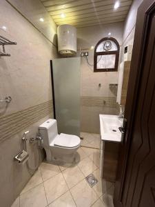 a bathroom with a toilet and a sink at Friday Suites in Al-ʿUla