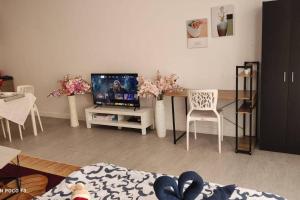 sala de estar con TV, mesa y sillas en BS412-Self-check-in-Wi-fi-Netflix-Pool-Parking-Klia, 5084, en Sepang