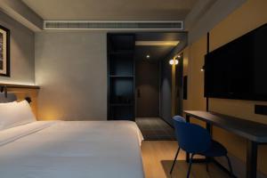 成都市にあるChengdu Desti Youth Park Hostel TaiKooLiのベッドと机とテレビがあるホテルの部屋