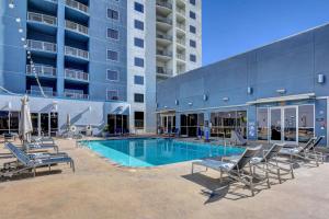 a swimming pool with lounge chairs and a building at Princess II Suite Platinum * Balcony Strip Views in Las Vegas